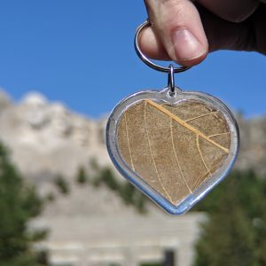 kratom heart keychain in front of Mount Rushmore